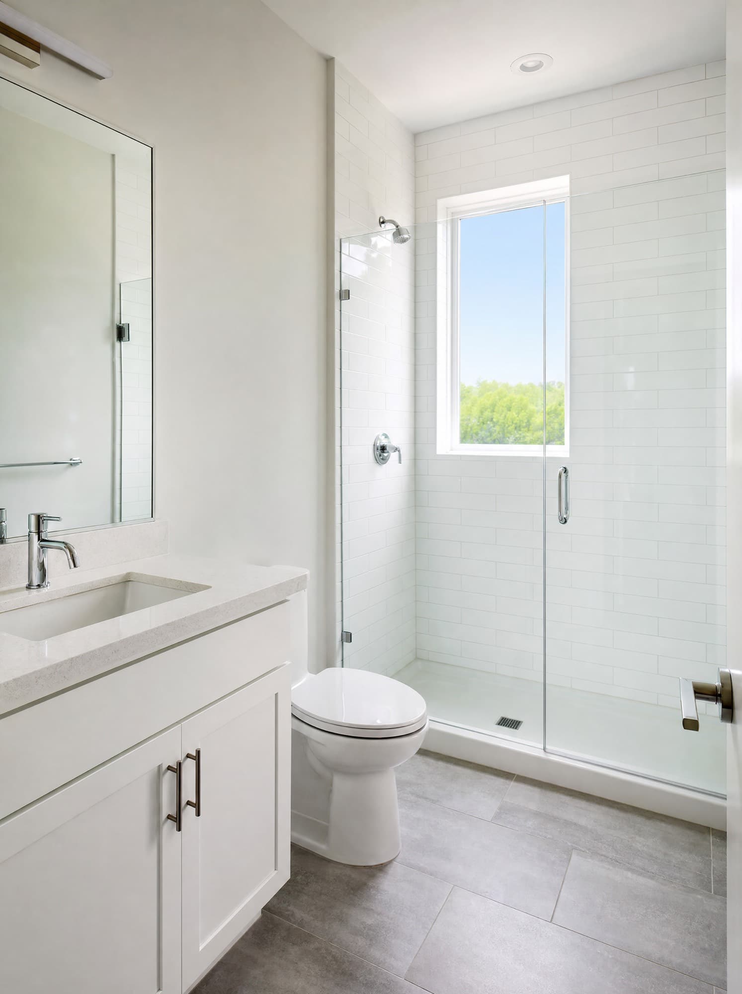 A spotless apartment bathroom with polished chrome fixtures and streak free shower glass